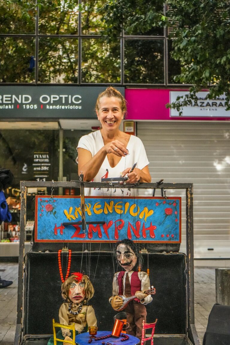 A lively street performance featuring a woman puppeteer showcasing marionettes in an urban setting.