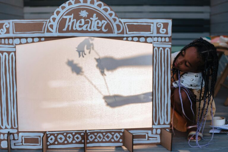 Young girl performing a shadow puppet show, showcasing creativity and leisure.